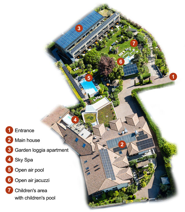 An aerial view of a hotel property with numbered areas marking key facilities such as the entrance, main building, apartments, outdoor pool, hot tub, and children's area.